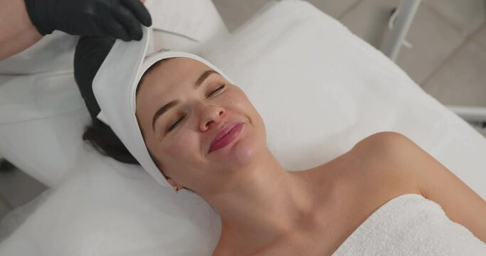 Facial massage in a beauty salon. Portrait of a young beautiful Caucasian woman.