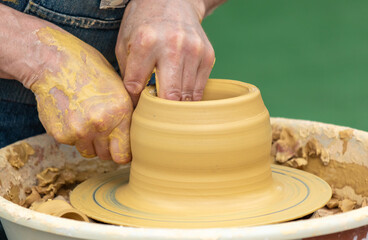 Clay craftsman sculpts crockery . Close-up.