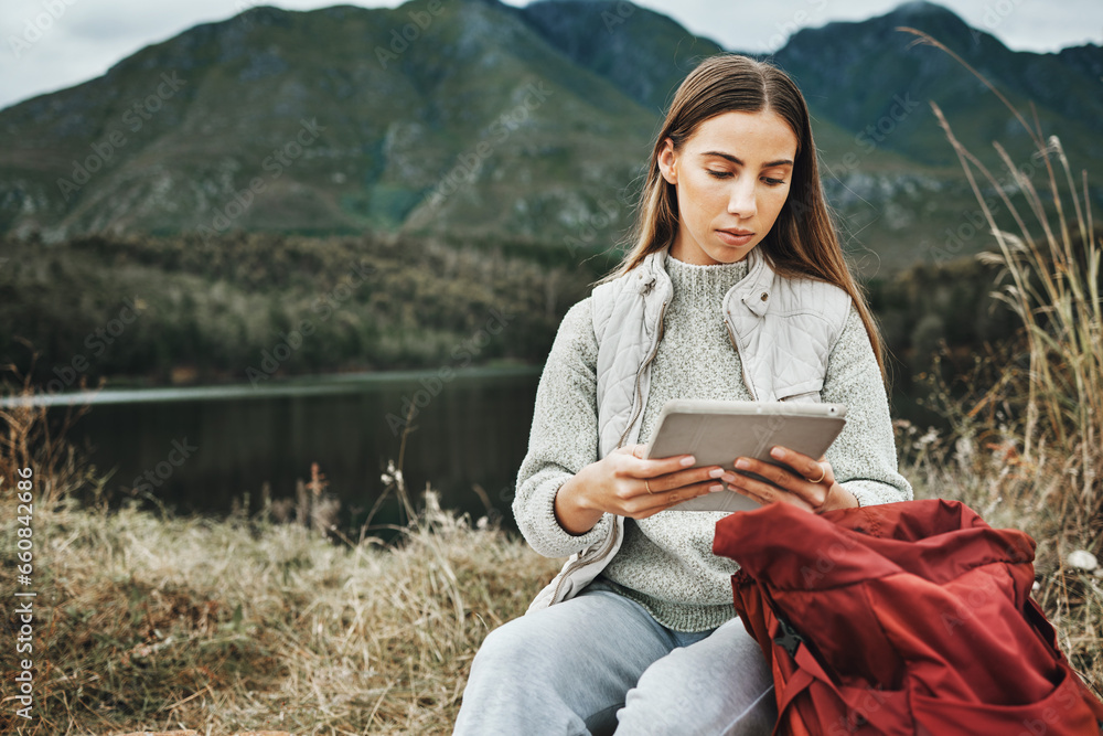 Wall mural Tablet, backpack and woman hiking in nature on mountain for adventure, weekend trip or vacation. Digital technology, bag and female person from Canada network on social media and trekking in forest.