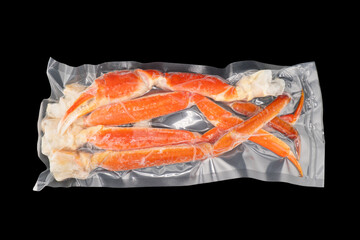 Vacuum packaged Peruvian Southern King crab leg isolated on a black background. Crab claws in vacuum package isolated on black background