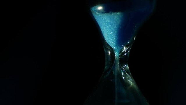 Hourglass cinematic. Neo-noir dystopian thriller, cyberpunk. Time flow. Einstein's theory of relativity. The cyclical nature of life. Izolated on black background. Smooth rotation and zoom