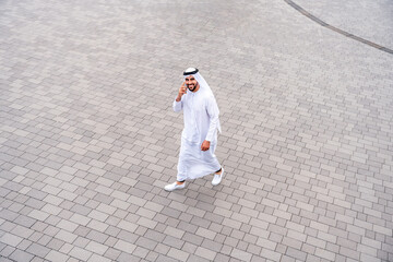 Arab middle-eastern man wearing emirati kandora traditional clothing in the city - Arabian muslim...