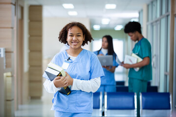 Portrait of happy smiling woman medical student holding school book have group students on background in classroom hospital medical school. concept of medical and education.
