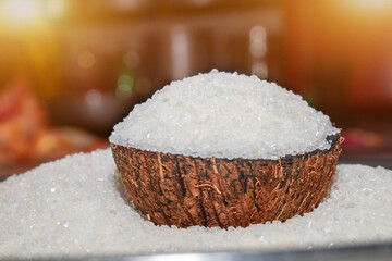 Sugar in a wooden bowl on background