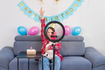 teenage girl with her funny pet dog are celebrating her birthday. Gen Z talent play video selfie shoot app for show share viral story. 