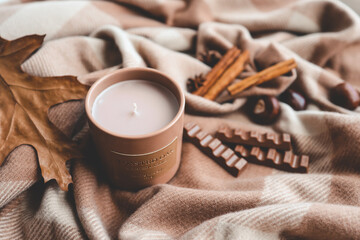 Candle with the scent of cinnamon and chocolate, cozy autumn