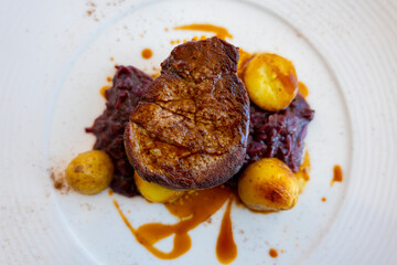 Beef Steak with Potato and Red Cabbage on a White Plate in Switzerland.