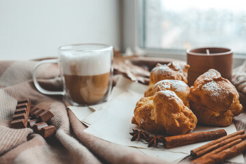 Cozy morning composition, cup of coffee, custard cakes and candle