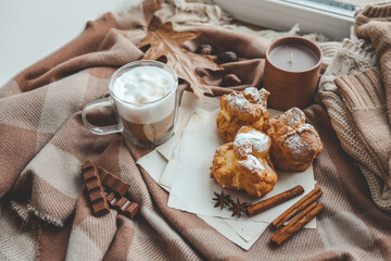 Cozy morning composition, cup of coffee, custard cakes and candle