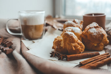 Cozy morning composition, cup of coffee, custard cakes and candle