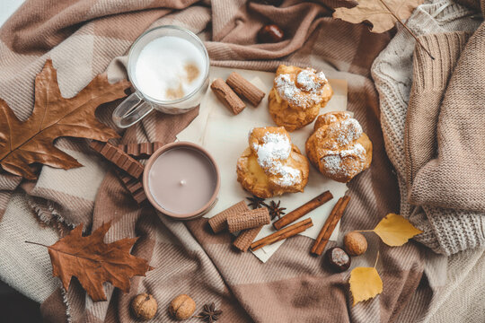 Beautiful cozy autumn background top view, candle, sweets and coffee