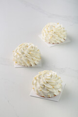 Fine French dessert and cakes on bright and white background. Petite Gateau and Entremet cakes. Well decorated celebration cakes. 