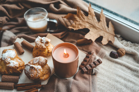 Burning candle with the smell of chocolate and cinnamon in a cozy home interior