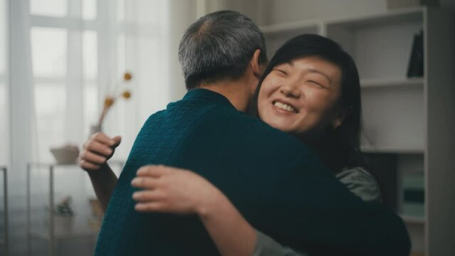 Smiling Asian woman hugging her senior father, dad and daughter relationship