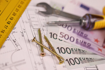 Spanner, screws and other repair tools on blueprints of residential house plan. Restoring, repair,...