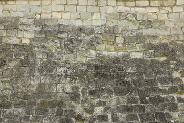 Very old brick stone wall of castle or fortress of 18th century. Full frame wall with obsolete dirty and cracked bricks