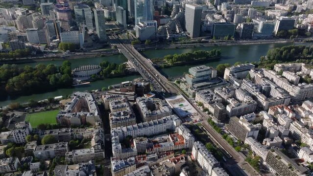 High angle view of busy bridge over Seine river. Tilt up reveal metropolis with La Defense business district. Paris, France