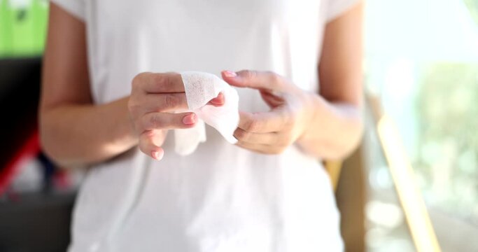 Right hand wipes left hand with piece of damp cloth. Hand sanitizer and hand hygiene