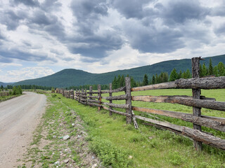Fototapeta na wymiar Wooden fence along the road in the Altai mountains, Russia