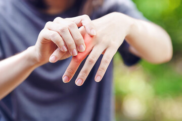 A woman touches a painful knuckle caused by rheumatoid arthritis.