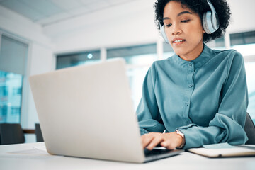 Headphones, laptop and woman typing in the office doing research for creative project. Computer, technology and professional female designer working, planning and listening to music in workplace.