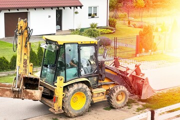 Yellow excavator on the road. Construction tractor moving.