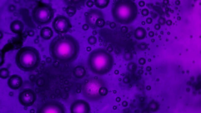 Chemical reaction in ultraviolet lighting of Ferric Chloride 3 and Baking Soda. Gas release. Observation in a chemical laboratory under a microscope. Automated artificial intelligence experiments