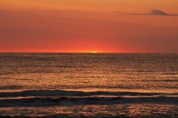 Radiant Sunset Over the Ocean. The Glowing Sun Sinking on the Horizon