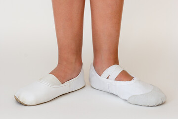 Cropped child legs in different ballet shoes © Tatiana Foxy