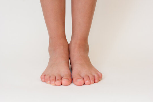 Cropped barefoot child legs on white background. 