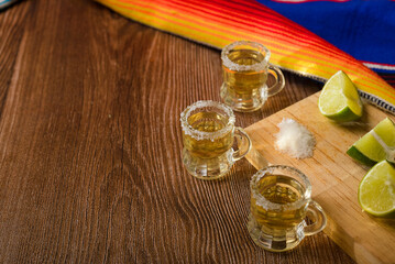 Tequila shots with salt and lime on a bar table. Shots of tequila and typical mexican elements.