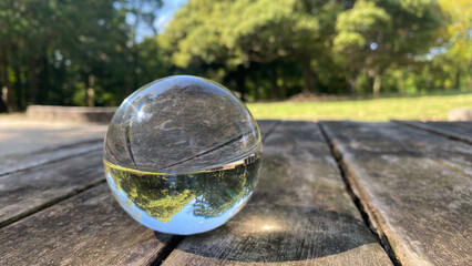 公園のテーブルにある透明な水晶ガラスボールの風景
