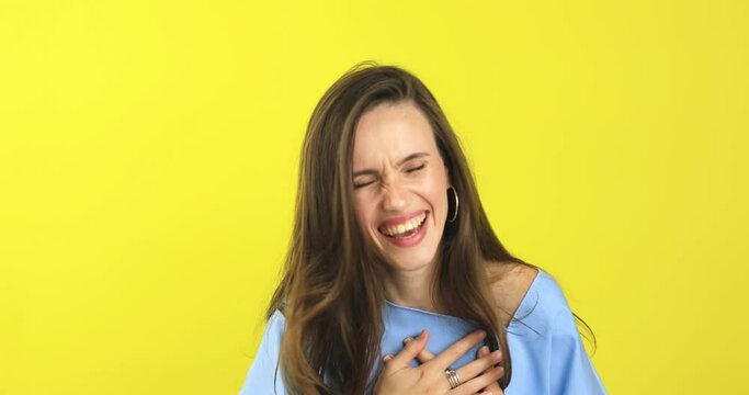 Young excited cheerful funny brunette woman look camera laugh smiling watch comedy movie, listening joke, pointing index finger on you isolated on yellow background studio portrait.