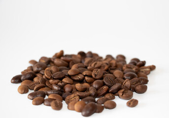 Coffee beans scattered. Aromatic brown coffee beans scattered on surface isolated on white background. Selective Focus.