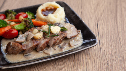 Pork shoulder steak with mushroom sauce, mashed potatoes and grilled vegetable