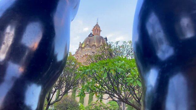 Fernando Botero square main building through legs of his sculpture in Medellin, Colombia