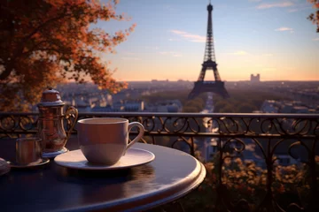 Fotobehang Night in Paris. A cup of tea or coffee is on the table on the balcony overlooking the Eiffel Tower © leriostereo
