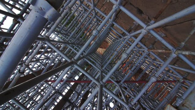 Motion through reinforcement iron mech carcass on brick wall closeup. Construction site supplies and material for building repair