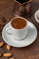 Turkish coffee in classic coffee cup with water and Turkish delight on wooden table