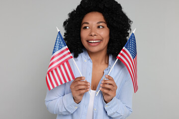 4th of July - Independence Day of USA. Happy woman with American flags on light grey background