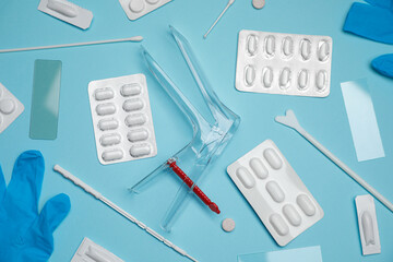 Sterile gynecological examination kit and pills on light blue background, flat lay