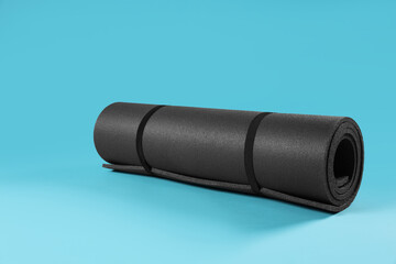 Grey yoga mat on light blue background