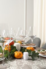 Beautiful autumn table setting. Plates, cutlery, glasses, pumpkins and floral decor