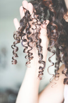 Close-Up of a woman's hand holding a ringlet of hair