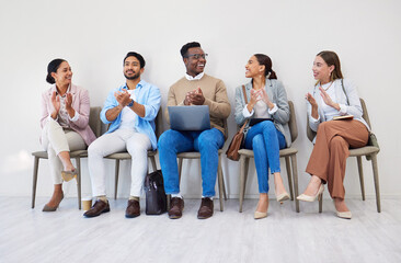 Obraz premium Business people, presentation and applause with smile in waiting room for interview, recruitment or we are hiring in a row. Men, women and group together for process, career and resume at company