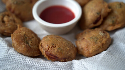 Pakora or pakoda, a traditional and popular Indian vegetarian snack, in a tray.