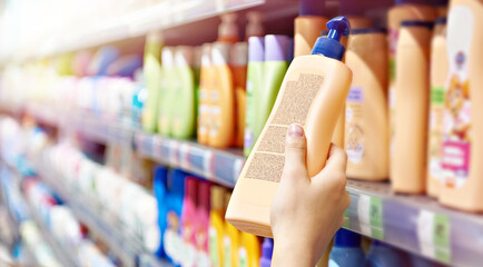 Plastic bottle of shampoo in hand - obrazy, fototapety, plakaty