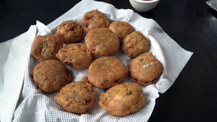 Pakora or pakoda, a traditional and popular Indian vegetarian snack, in a tray.