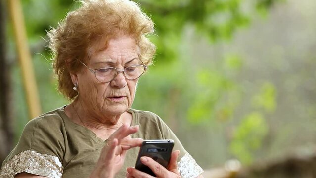 senior woman with mobile phone outdoors