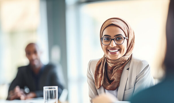 Muslim businesswoman leading a discussion during an meeting in a creative office. Group of multicultural businesswomen having a video conference with their business associates.